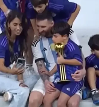 La familia de Messi celebra la victoria en el Mundial de Qatar 2022, con Lionel Messi sosteniendo a su hijo mientras su esposa toma una selfie.